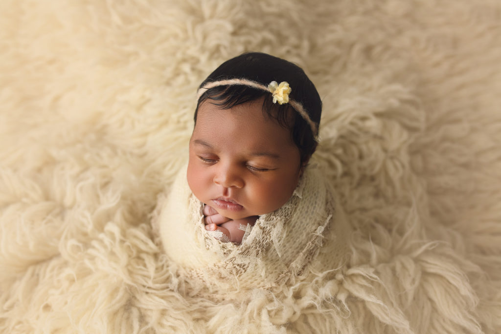 Newborn baby girl in white fur