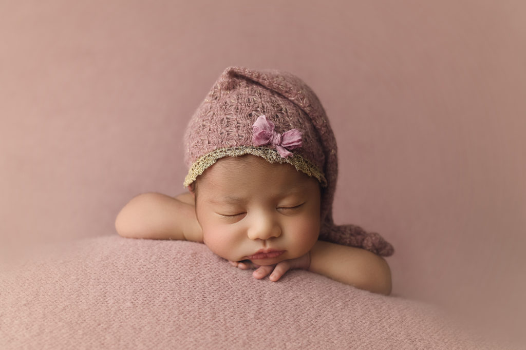 Newborn baby girl in pink hat