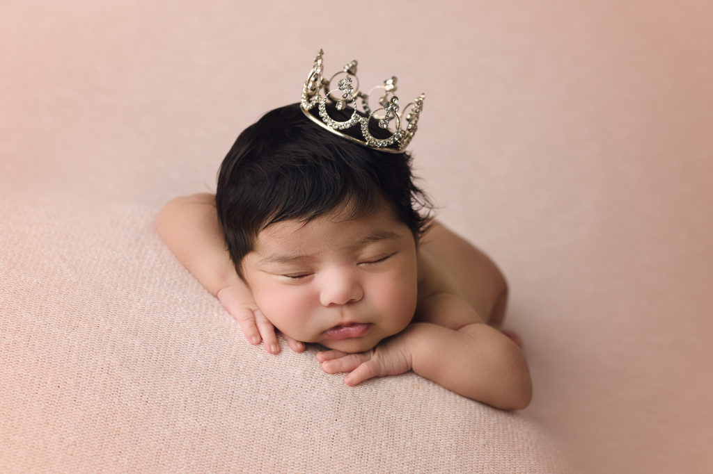 newborn baby girl wearing crown