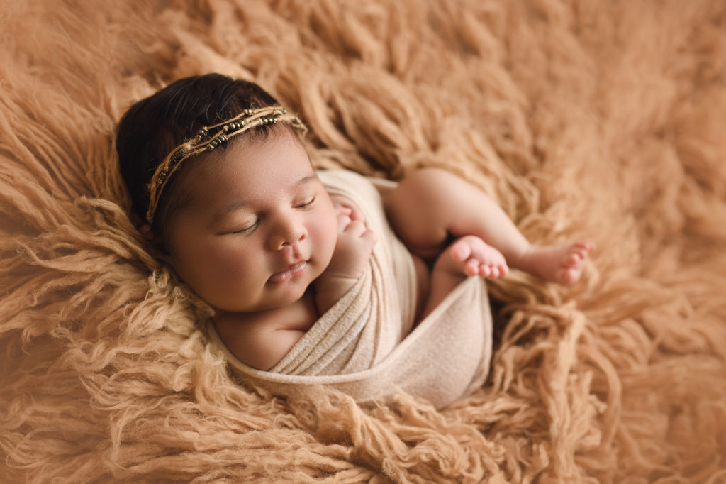 newborn baby girl in beige fur