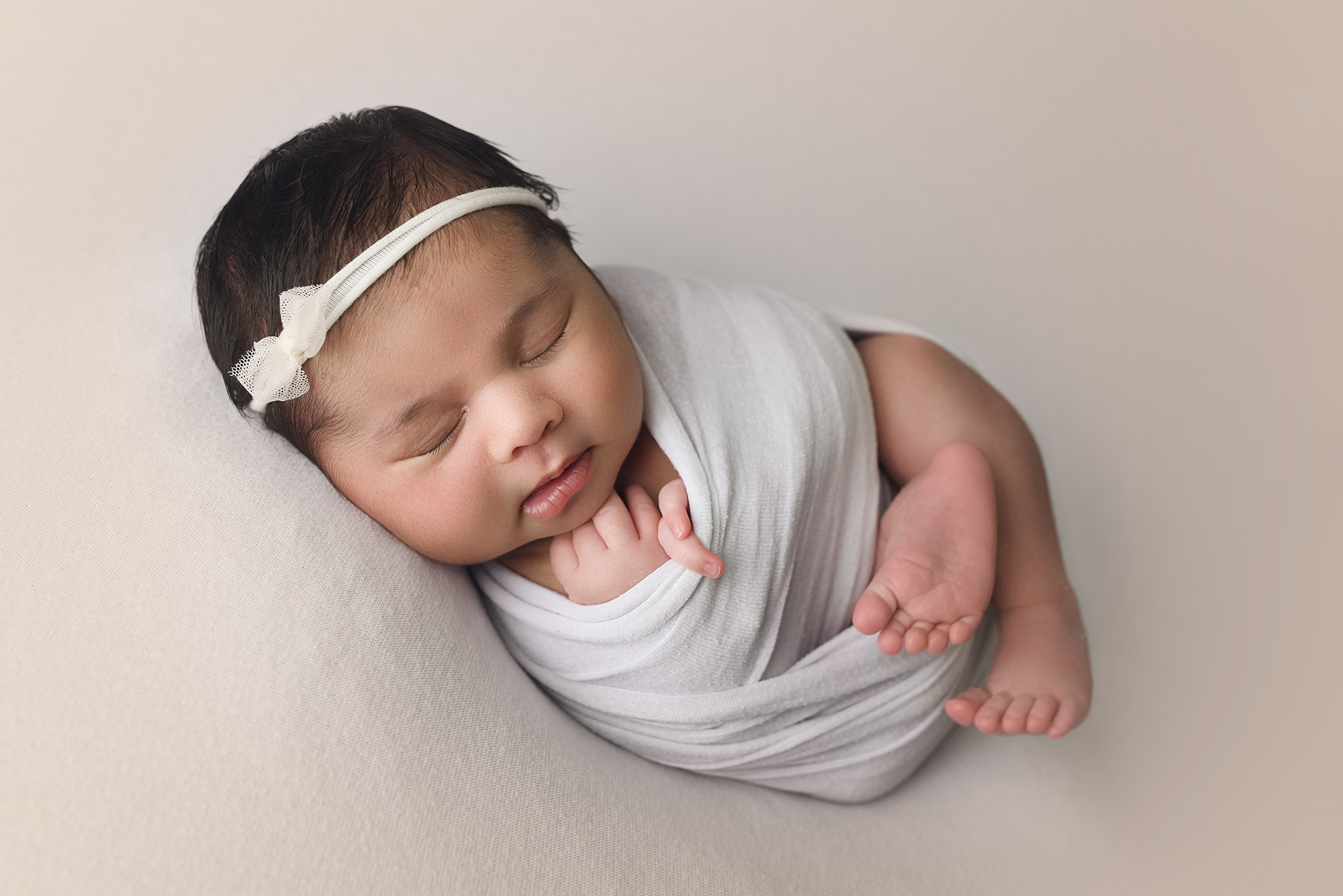newborn baby girl wrapped in white