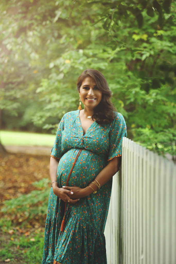 Pregnant mom in green dress and white fence