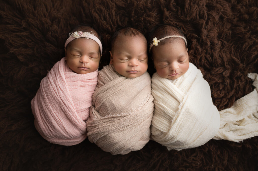 Newborn Triplets wrapped up and laying on brown fur