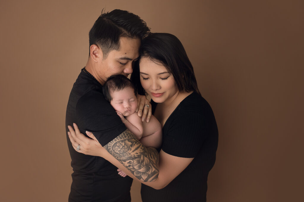 newborn baby boy held in daddy's arms with tattoos
