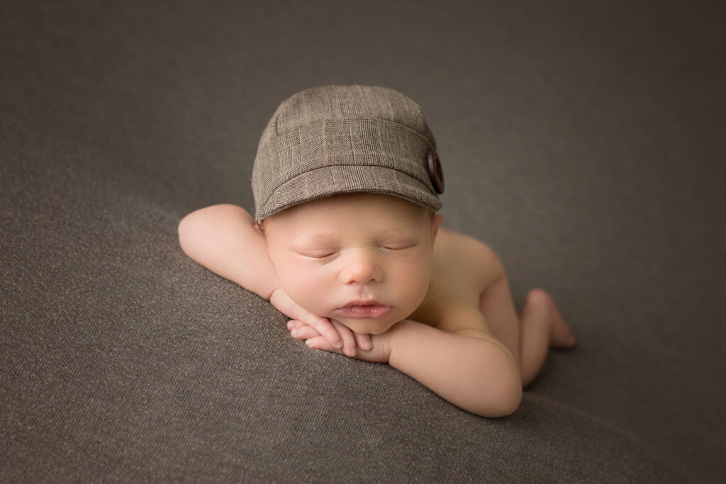Newborn Baby Boy face forward in brown drivers hat