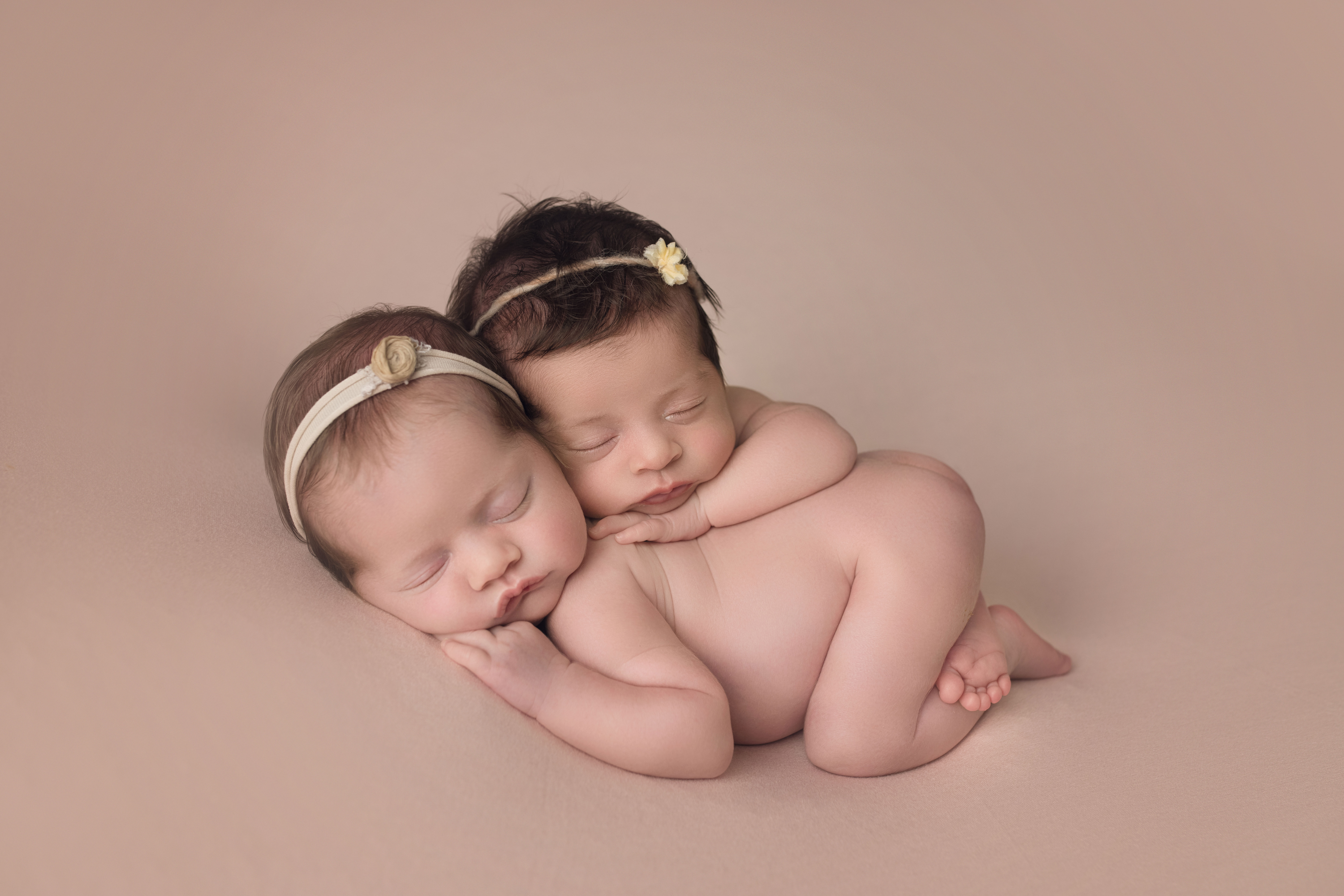 newborn twin girls bum up on pink blanket