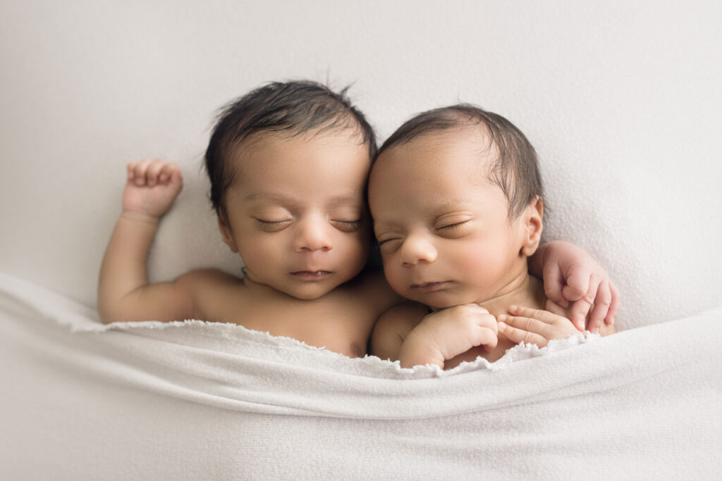 Newborn Twin Boys laying on back snuggled together