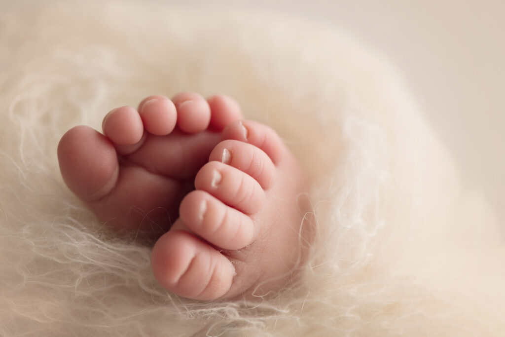 newborn babys hand in a fist raised high How to Prepare for your Newborn Photo Session
