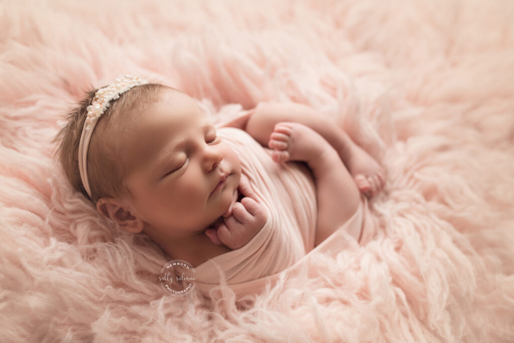 Newborn Photography Raleigh NC Newborn Baby Girl curled in a pink wrap in pink fur