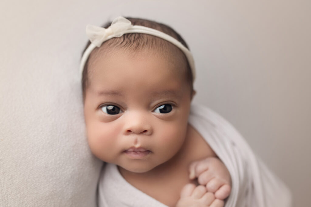 Newborn Baby Girl eyes wide open with white bow