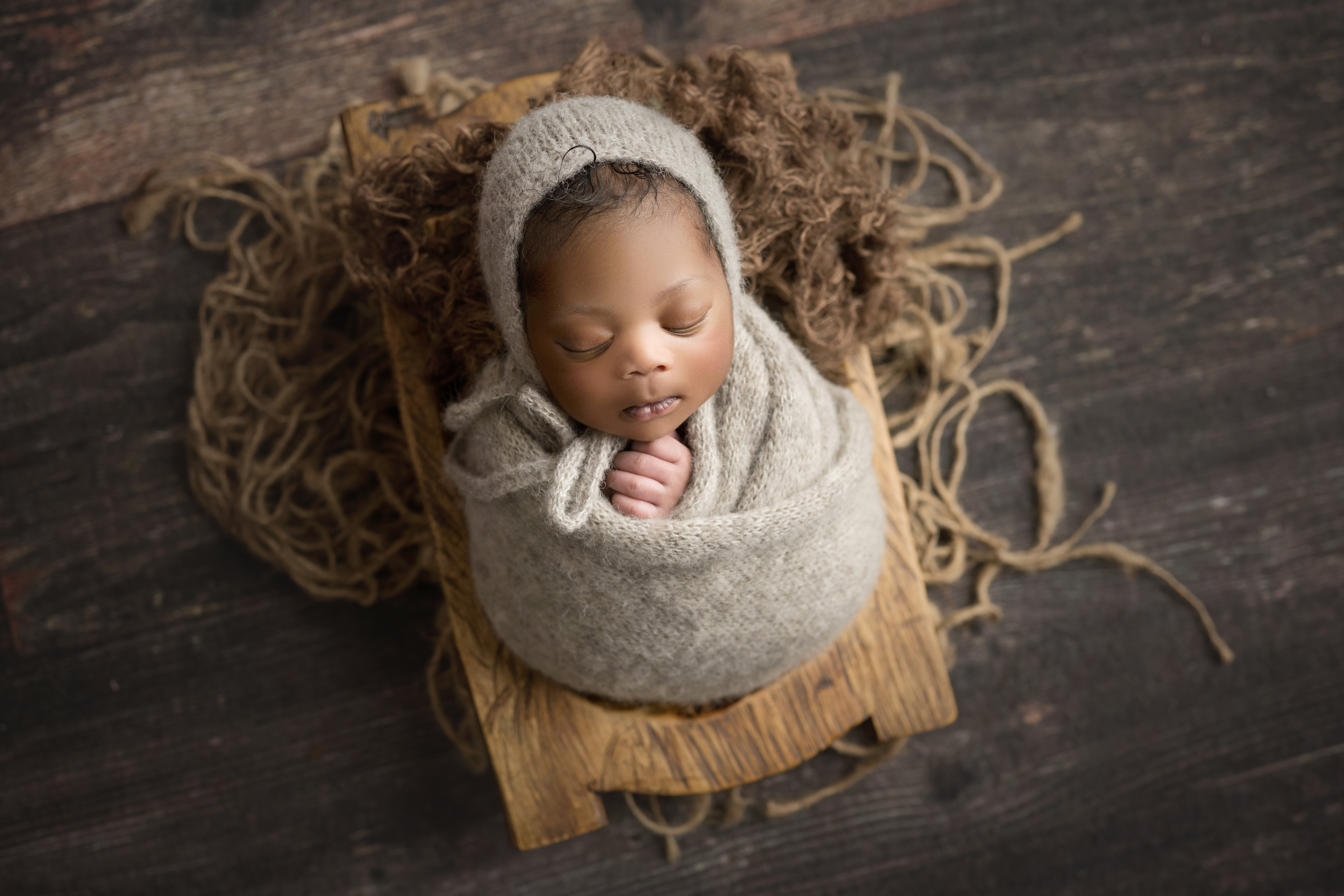newborn baby boy wrapped in brown with matching bonnet
