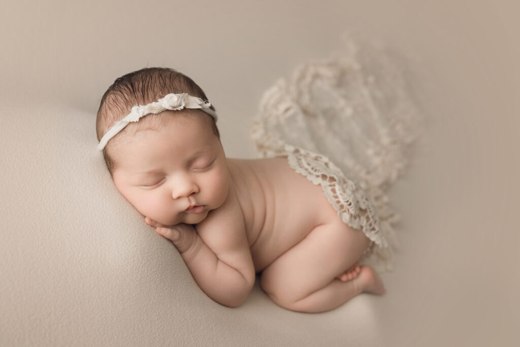 ### Raleigh Newborn Photographer baby girl bum up on cream blanket with cream lace wrap