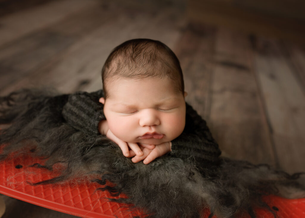 A newborn boy sleeping on a skateboard. Cary Newborn Photographer | Baby James