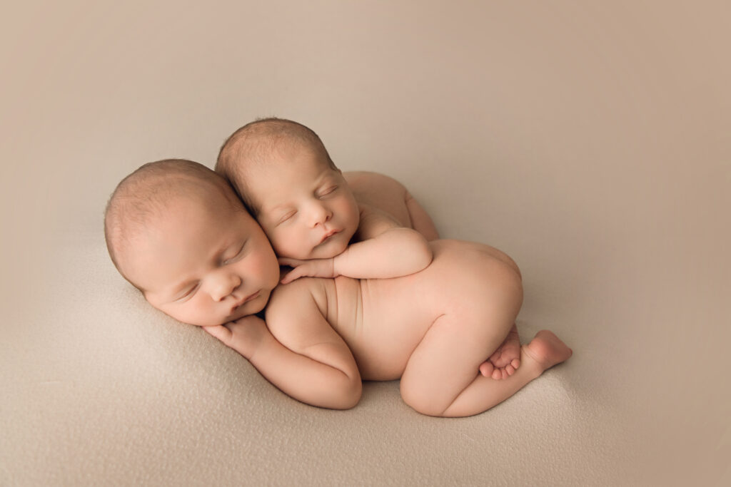 Newborn Baby twin bum up on cream blanket