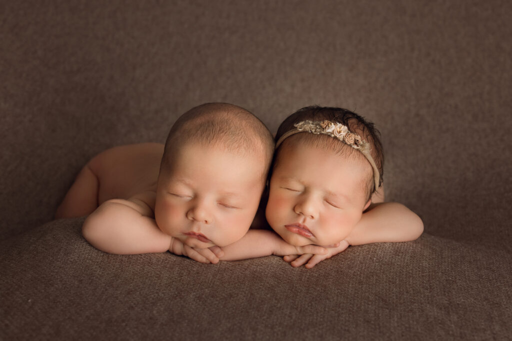 Newborn twin babies sleeping on brown textured background. Double the Joy: Newborn Photography for Twins in Raleigh